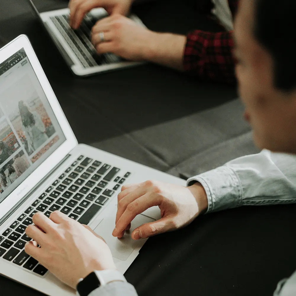 Medewerkers werken op laptops aan een gedeelde tafel