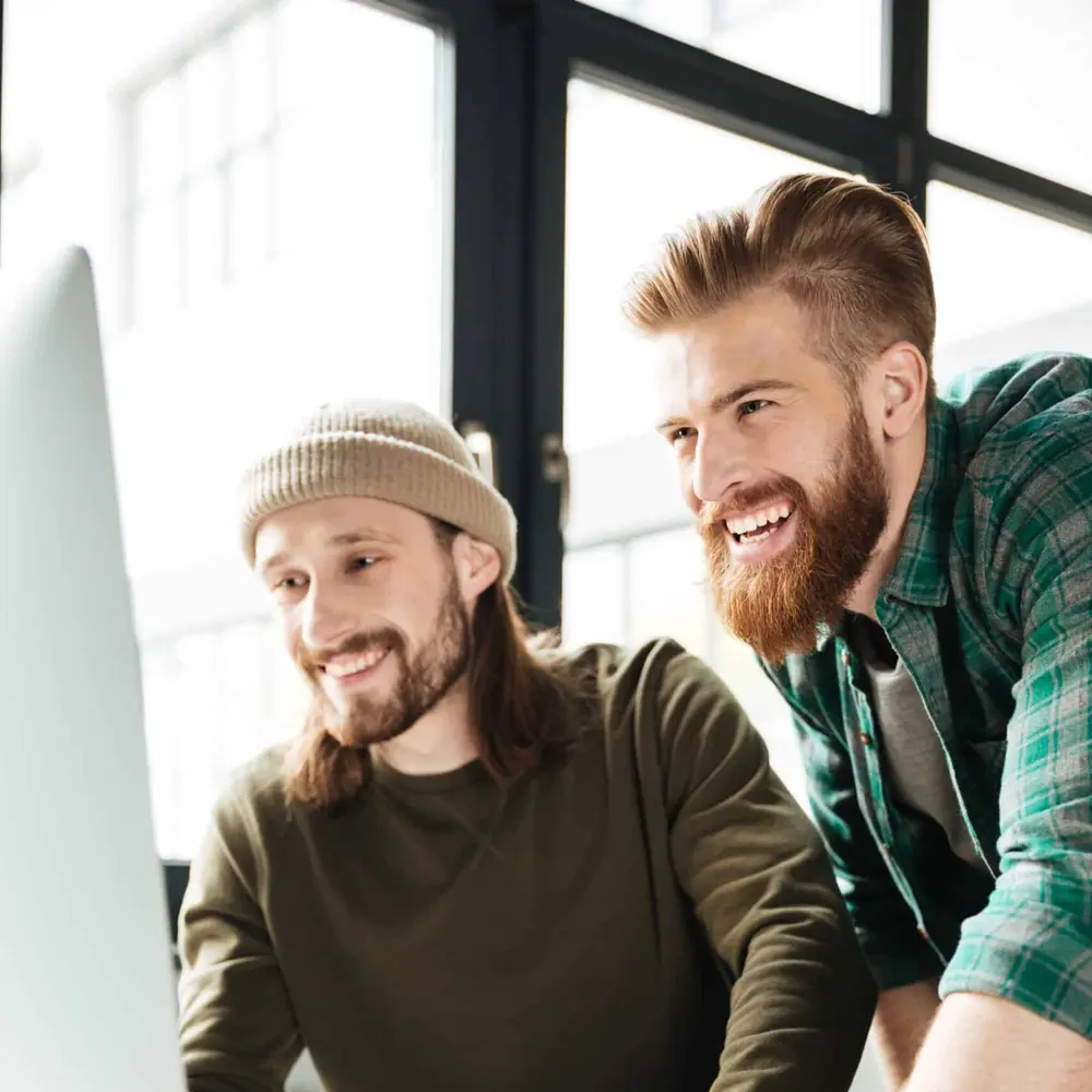 Twee collega's bekijken samen een applicatie op het scherm